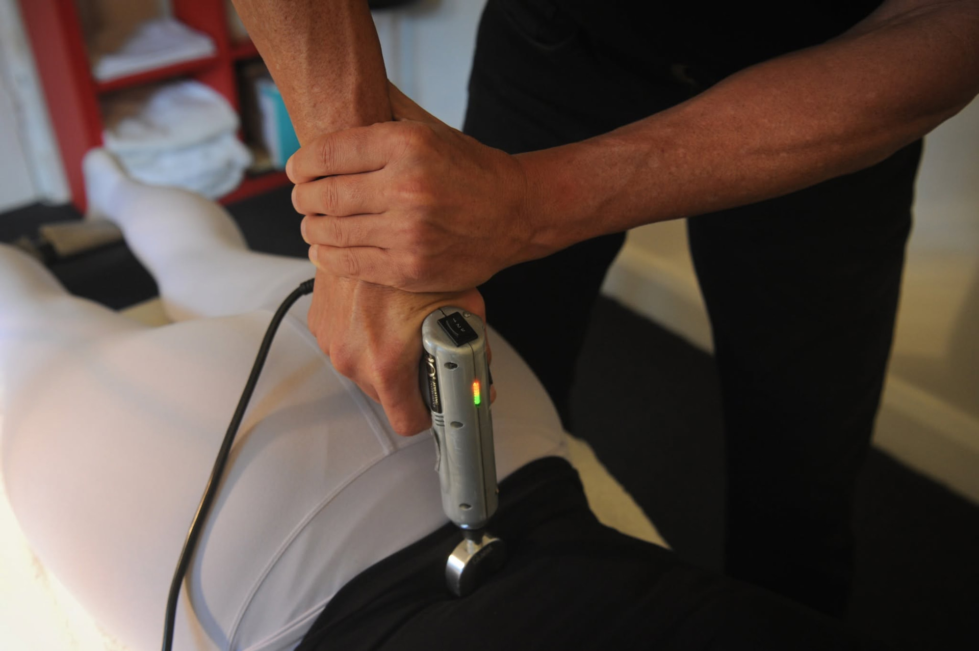 Chiropractic adjusting instrument being used on a patient's lower back